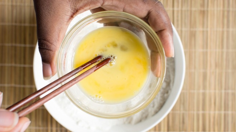 chopsticks scrambling eggs in a bowl