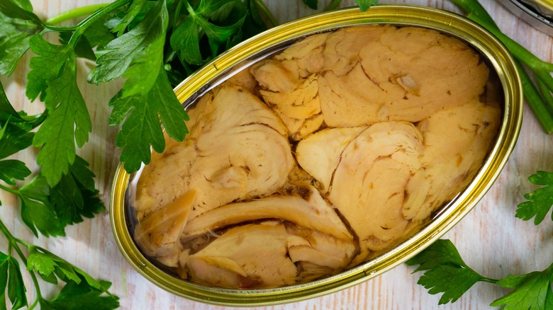 Open canned tuna in oil alongside parsley