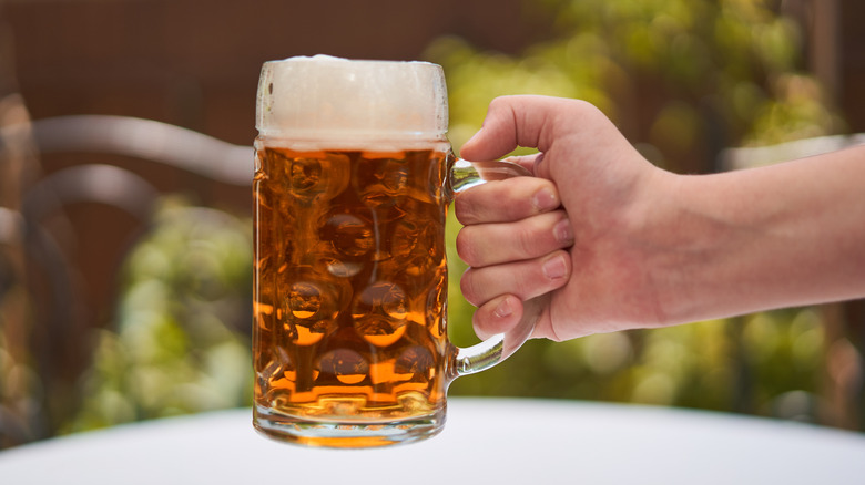Person holding glass of German Pilsner beer