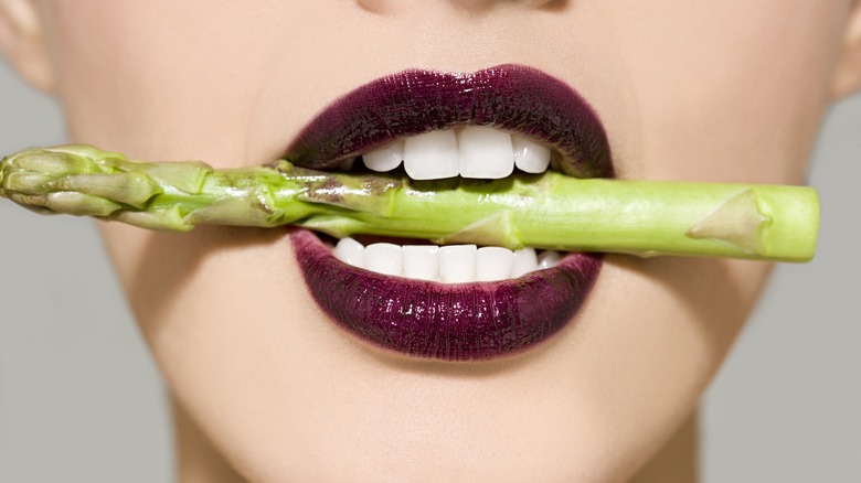 woman's mouth with asparagus