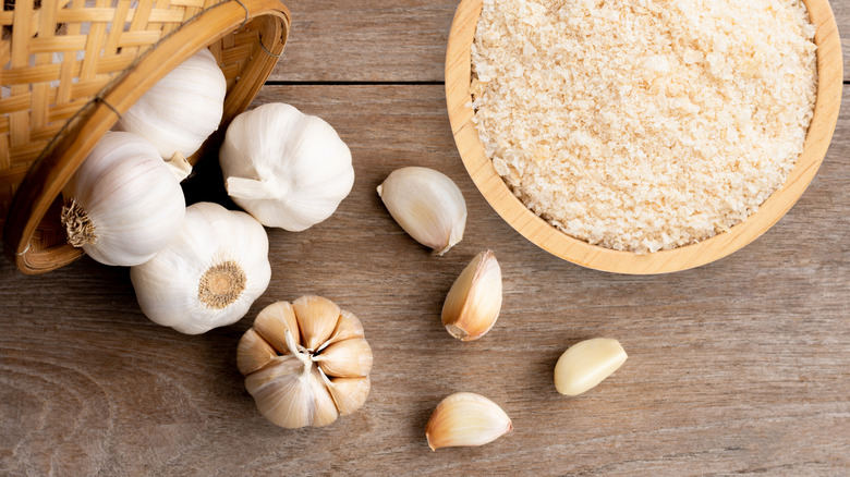 garlic powder surrounded by garlic bulbs