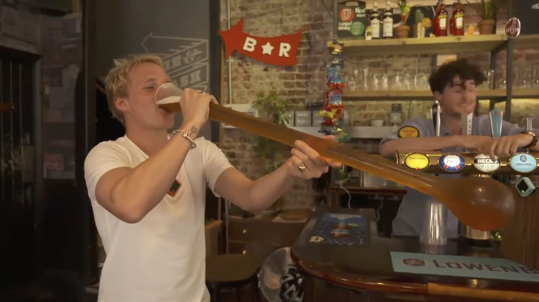 Person drinks from yard glass at beer