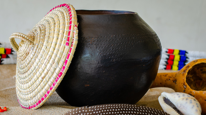 Lid resting on side of Zulu beer clay pot