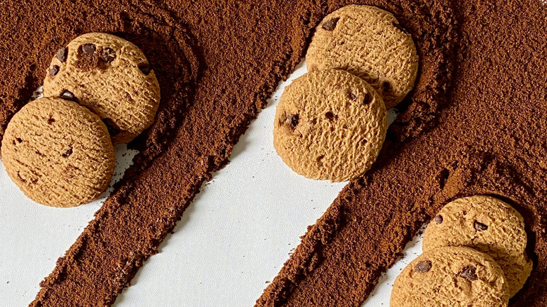 Chocolate chip cookies surrounded by dry coffee grounds