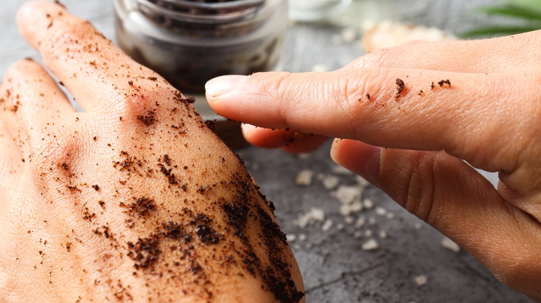 Person scrubbing coffee grounds on their hands