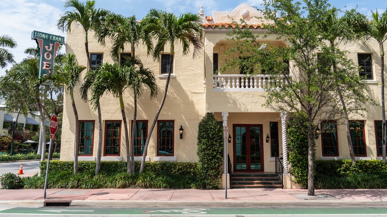 The exterior of Joe's Stone Crab with tan stucco and red clay roof tiles