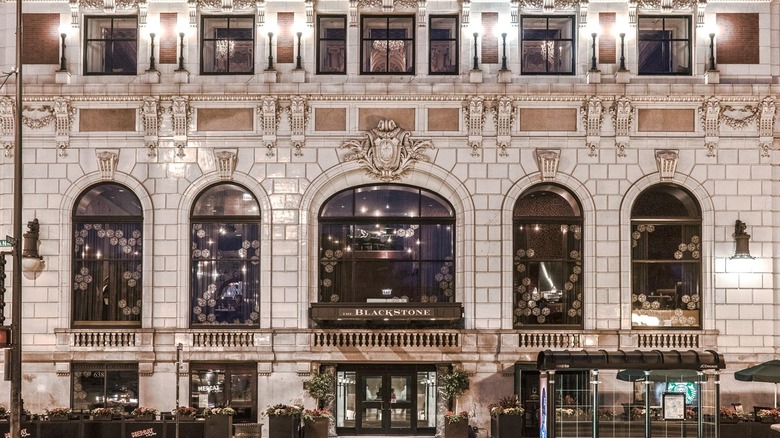 The exterior of The Blackstone Hotel with large glass windows and ornate stone