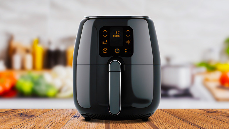 Generic black air fryer on table with no branding