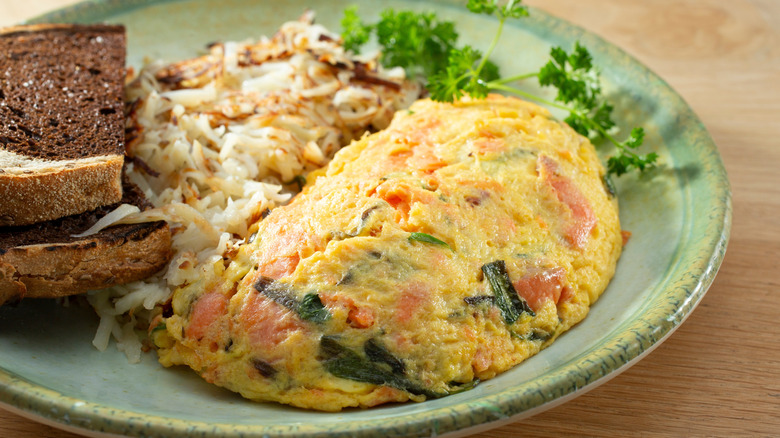 A salmon omelette with hashbrowns and toast