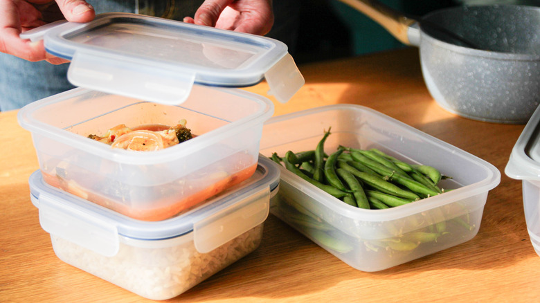 three plastic containers with a person putting a lid onto one of them