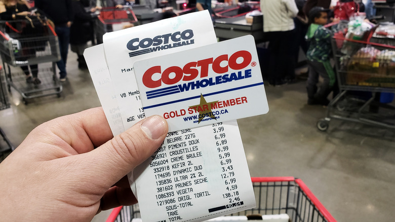 Hand holding Costco membership card and reciept