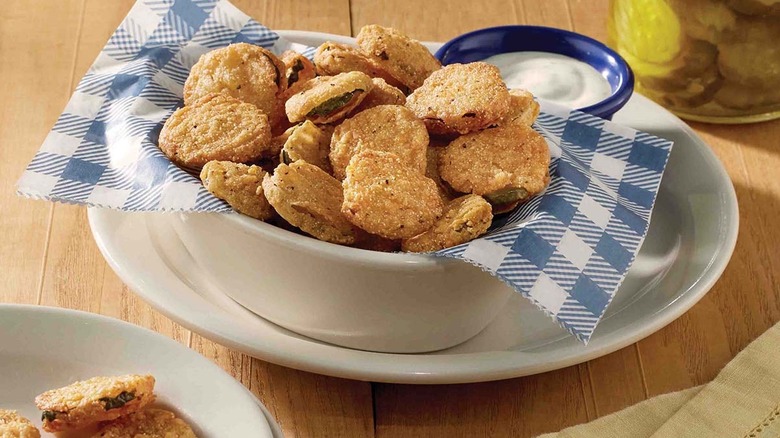 country fried pickles in a bowl with a smaller bowl of dipping sauce on the side.