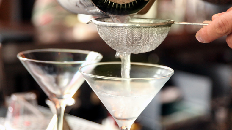 pouring martini through strainer