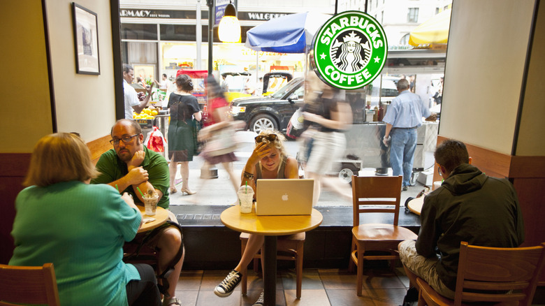 Interior of a Starbucks cafe with people working and talking
