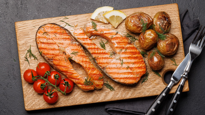 Grilled salmon steaks on board