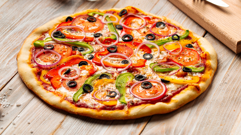 vegetable pizza on wooden counter