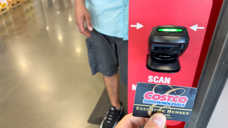 Person holding membership card in front of scanner