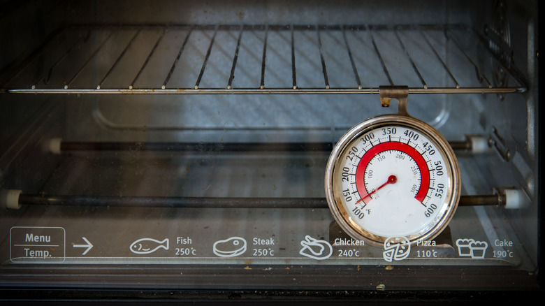 An oven thermometer attached to the rack inside an oven