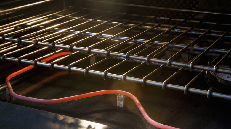 An empty oven with two racks and a red heat coil