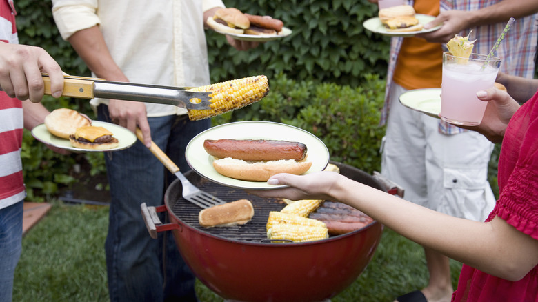 People gathered around a charcoal grill