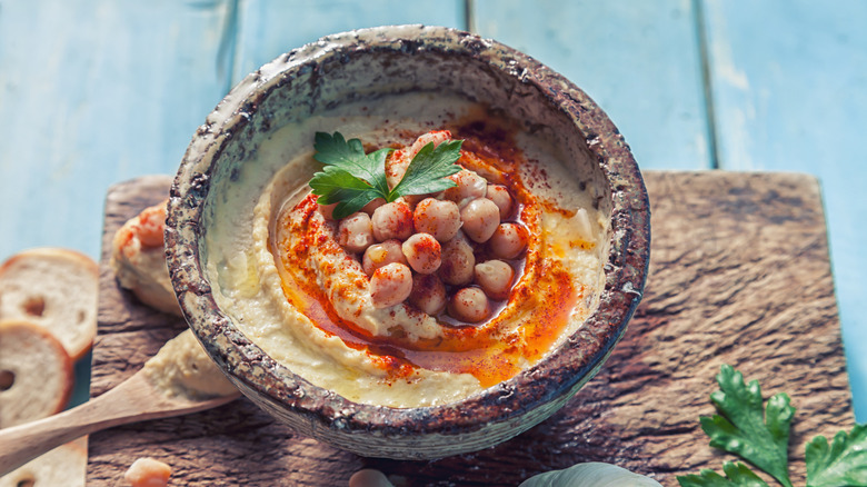 Hummus with chickpeas and herbs in a bowl