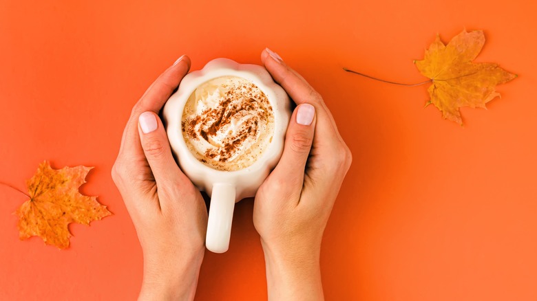 Hands holding pumpkin spice latte