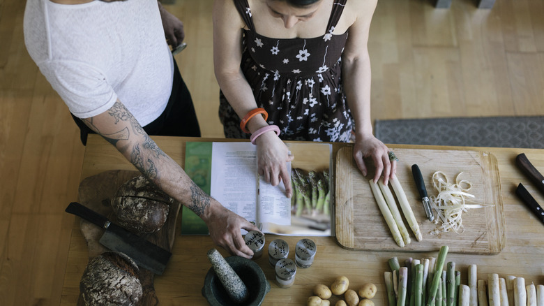 Overhead view of couple reading a recipe while cooking