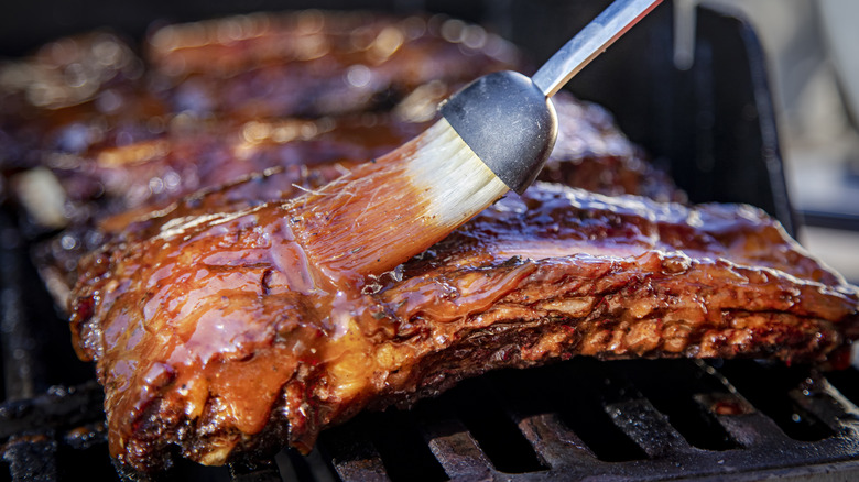 Person basting barbecue sauce