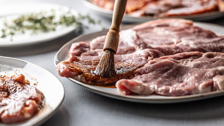 Brushing marinade over BBQ meat