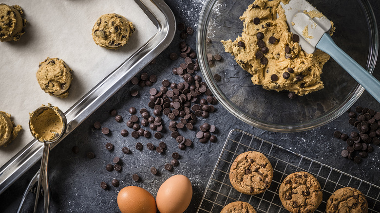 Cookie dough in a large bowl, portioned dough on a baking sheet, and baked cookies on a cooling rack