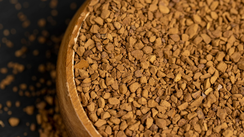 Closeup of a wooden bowl filled with instant coffee