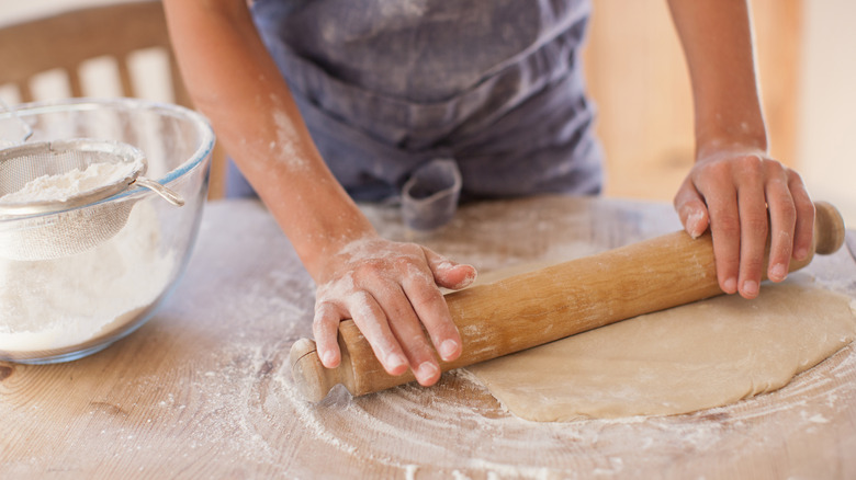 hands rolling out dough