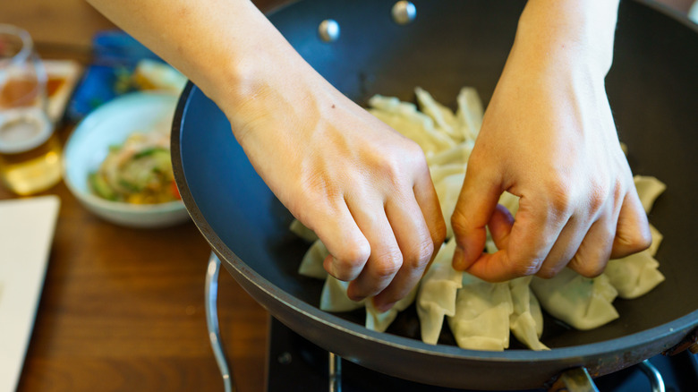 Cooking jiaozi in a wok