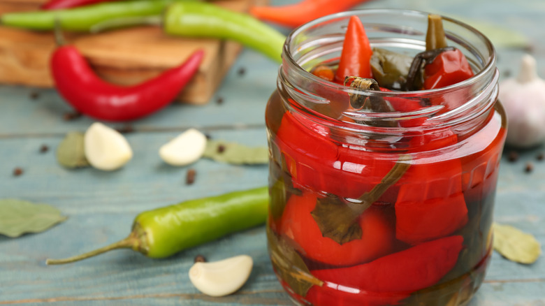 glass jar of pickled red chili peppers