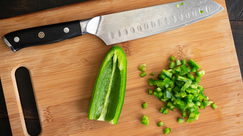 chopped jalapeño with knife on a cutting board