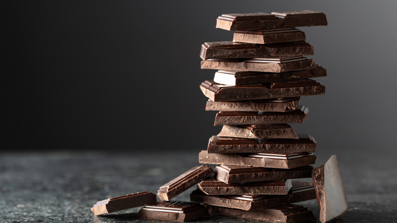 Several squares of dark chocolate stacked on top of each other.