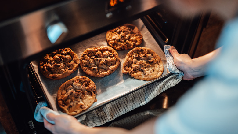 pulling cookies from oven