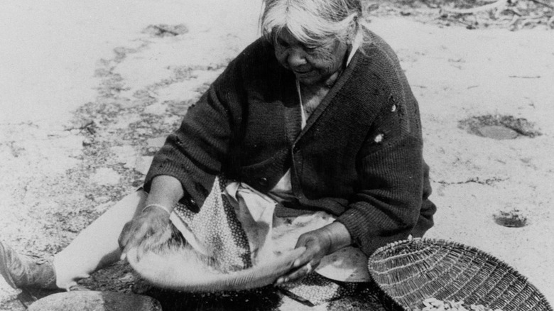 Native American woman grinding acorns into flour