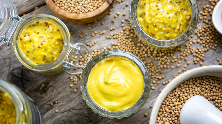 jars of mustard and bowls of mustard seeds