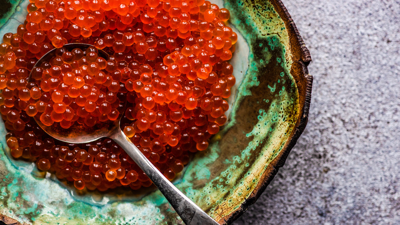 Rustic clay bowl of salmon caviar