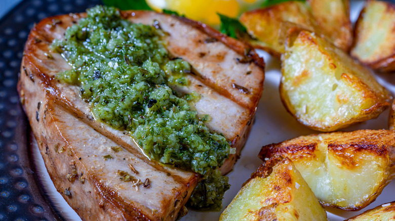 Grilled tuna steak with roasted potatoes and chimichurri sauce