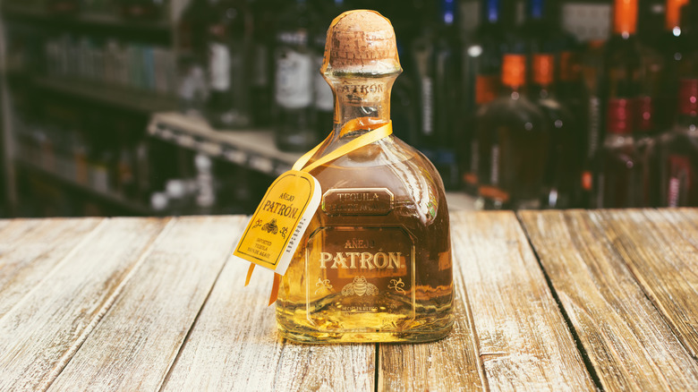 A bottle of añejo Patron sitting on a wooden table