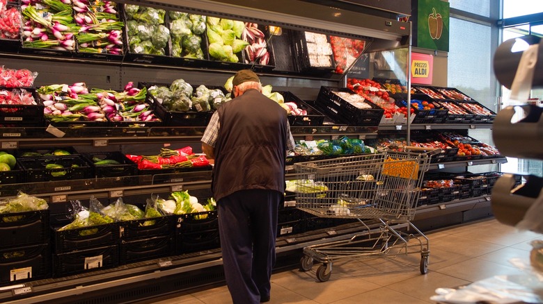 man standing in front of produce aisle at Aldi's