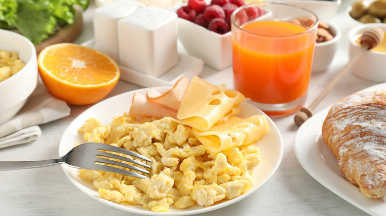 Plate of scrambled eggs with other breakfast food