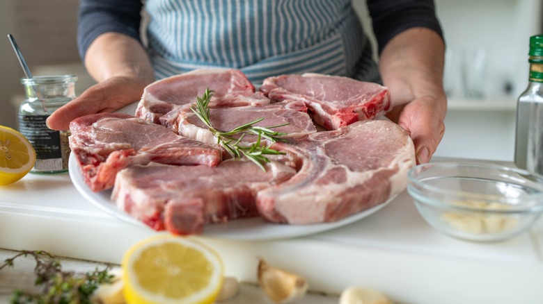 Woman holding raw pork chops