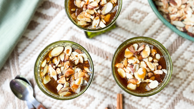 Almond chai chia pudding in serving dishes with almonds and syrup