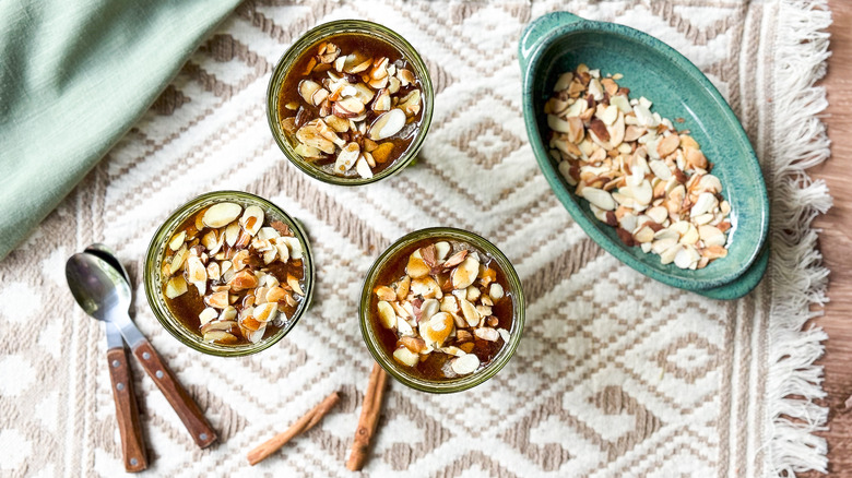 Almond chai chia pudding in serving cups with almonds on table