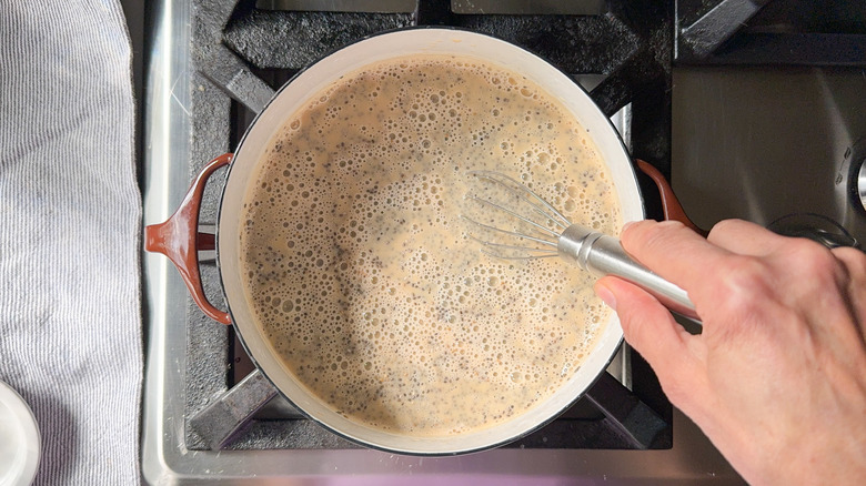 Whisking chia seeds into almond milk chai in pot on stovetop