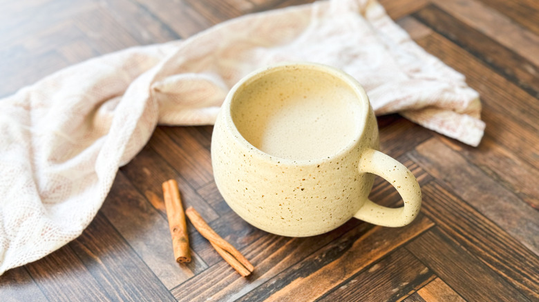 Chai tea in mug with napkin and cinnamon sticks