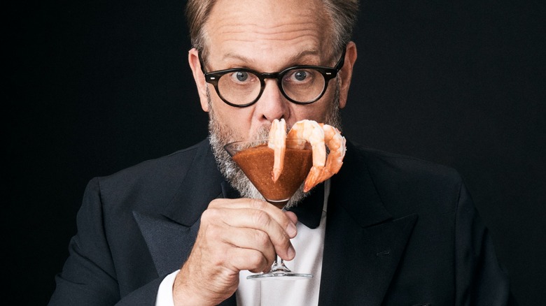 Alton Brown holding shrimp cocktail